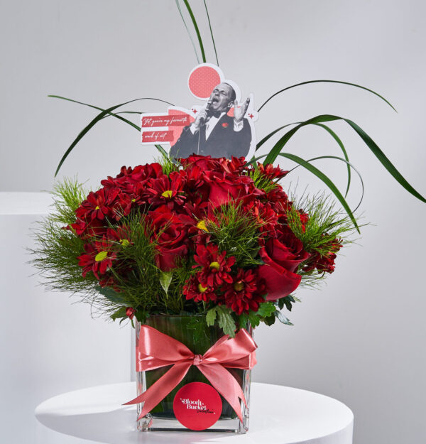 فازة ورد أحمر مع عشب أخضر